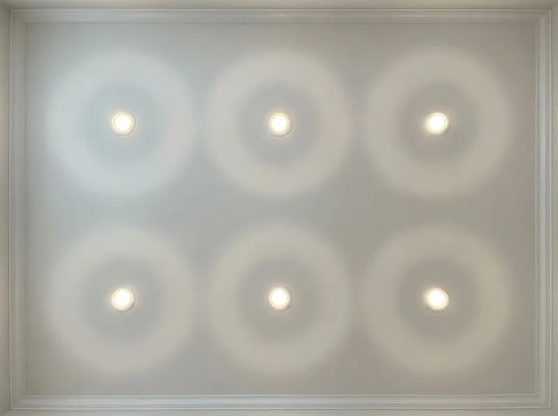 Six evenly spaced recessed LED can lights in a 2x3 grid pattern on a white living room ceiling